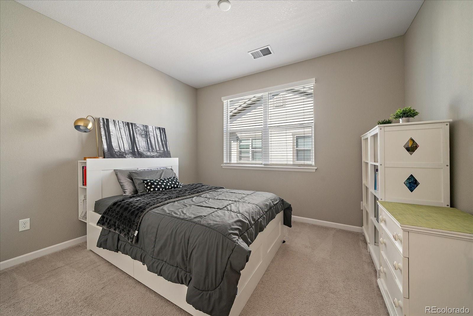 4474 Copeland Circle, Unit 203 Highlands Ranch, CO 80126 - Photo 19 of 33 a bedroom with a bed and a window