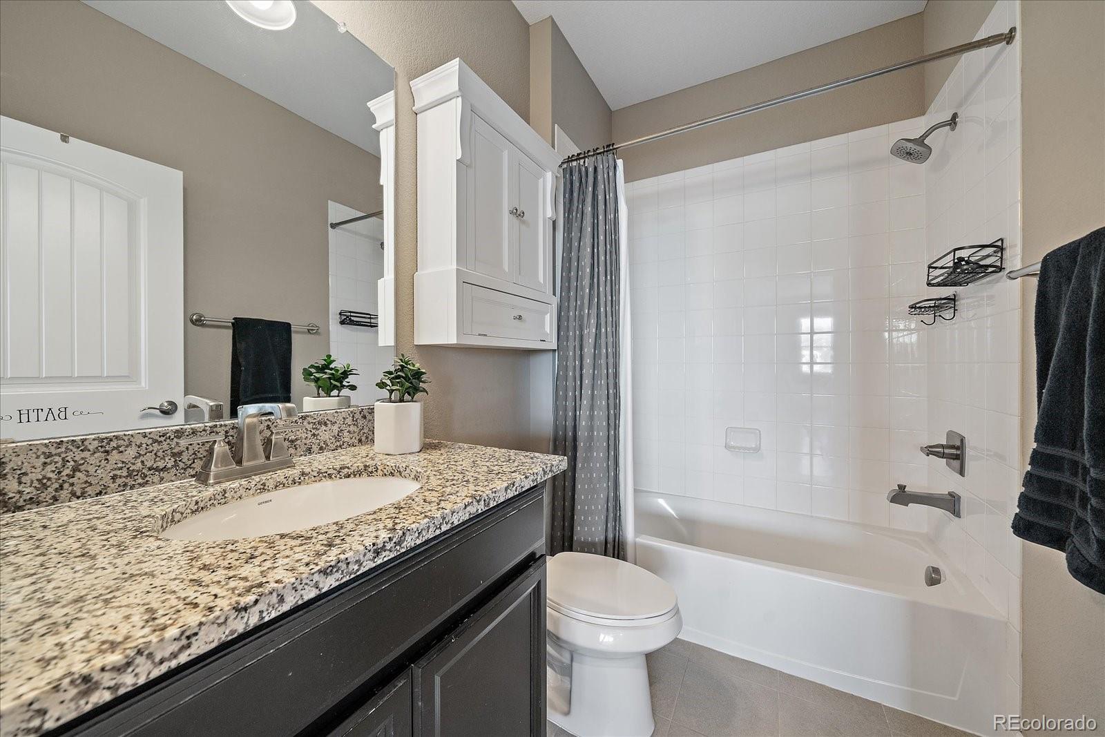 4474 Copeland Circle, Unit 203 Highlands Ranch, CO 80126 - Photo 20 of 33 a bathroom with a granite countertop sink mirror toilet and bathtub