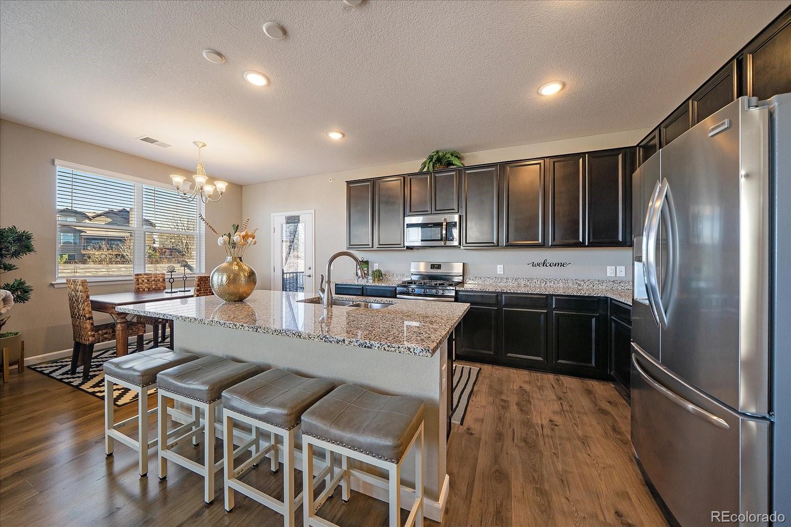 4474 Copeland Circle, Unit 203 Highlands Ranch, CO 80126 - Photo 9 of 33 a kitchen with granite countertop a refrigerator and a stove top oven