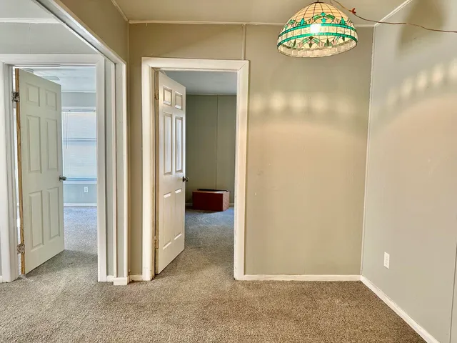 an empty room with a ceiling fan and shower