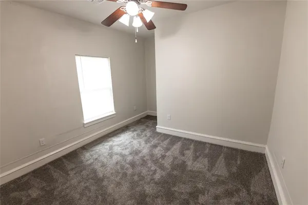 an empty room with a fan and a fan