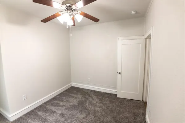 an empty room with a chandelier fan