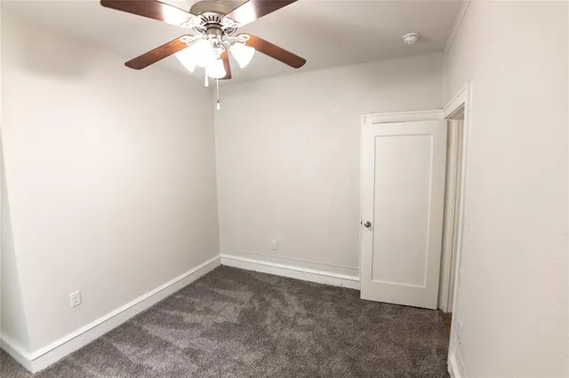 an empty room with a chandelier fan