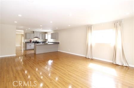 1007 Del Rey Avenue Pasadena, CA 91107 - Photo 6 of 15 a view of a kitchen with kitchen island a sink wooden floor and a large window