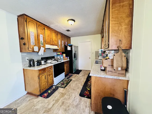 a kitchen with stainless steel appliances granite countertop a sink a stove and a refrigerator