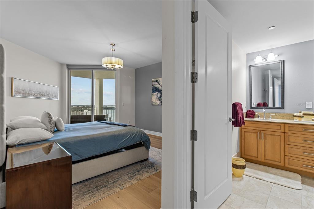 331 Cleveland Street, Unit 2102 Clearwater, FL 33755 - Photo 25 of 66 a bedroom with a bed and a chandelier