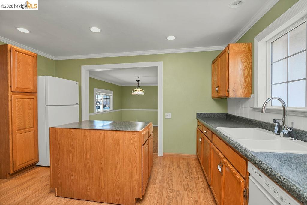 805 Calero Street Milpitas, CA 95035 - Photo 7 of 23 Kitchen featuring wood-finish flooring, an integrated island, light wood cabinetry, recessed ceiling lighting, and a window with grid detailing