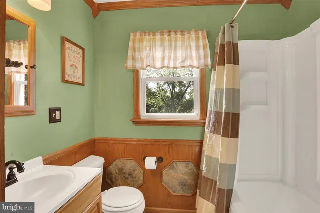 a bathroom with a sink toilet and window