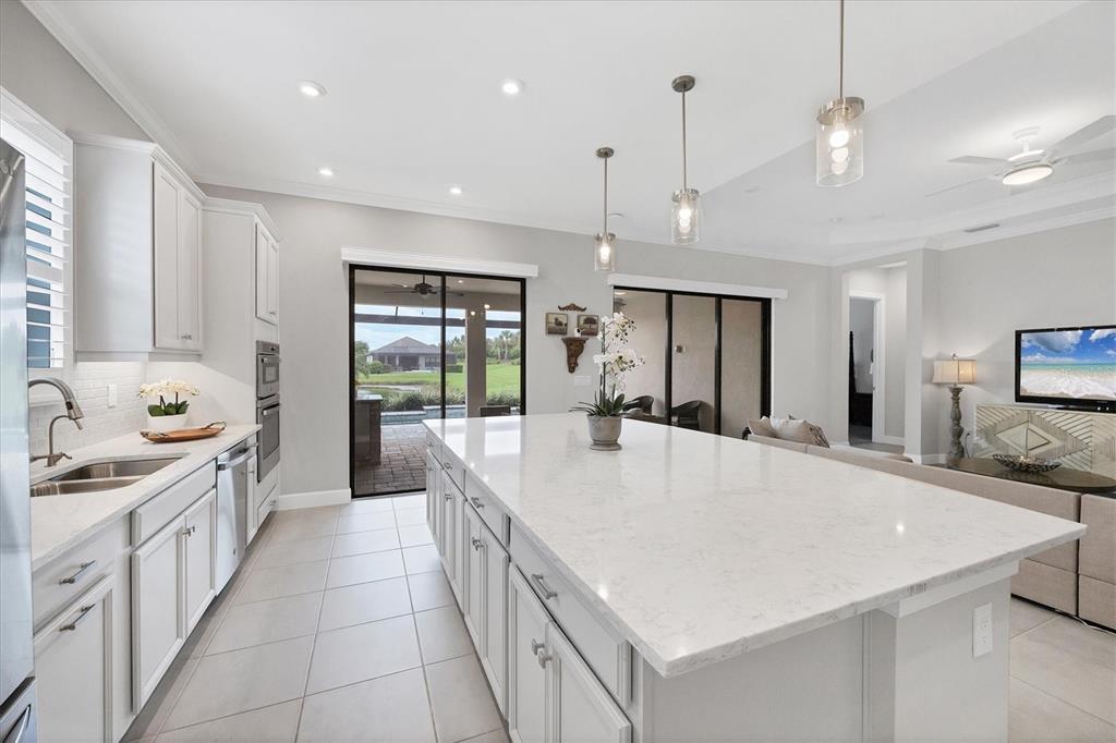 4735 Cassio Court Bradenton, FL 34211 - Photo 12 of 100 a large white kitchen with a large window a sink and stainless steel appliances