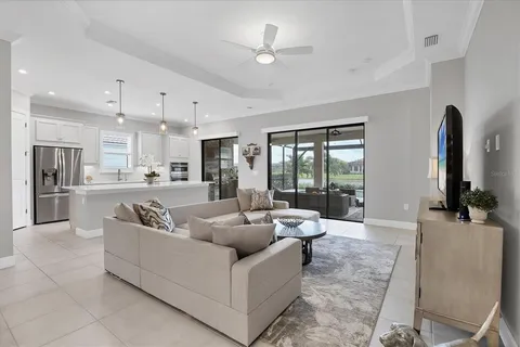 a large white kitchen with lots of counter space a sink appliances and cabinets