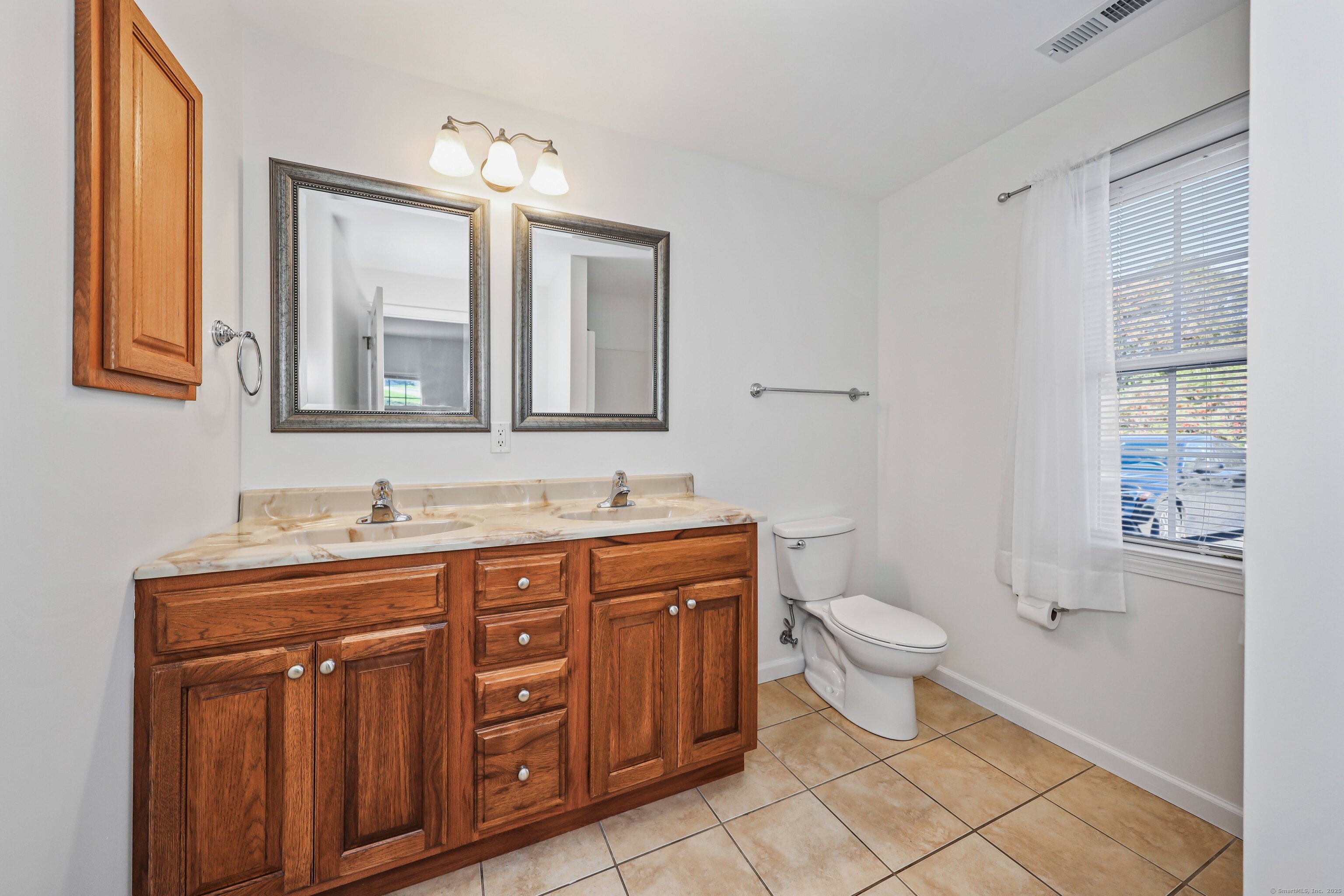 211 Pine Hill Boulevard, Unit 211 Plymouth, CT 06782 - Photo 15 of 35 a bathroom with a toilet a sink a mirror a and a window