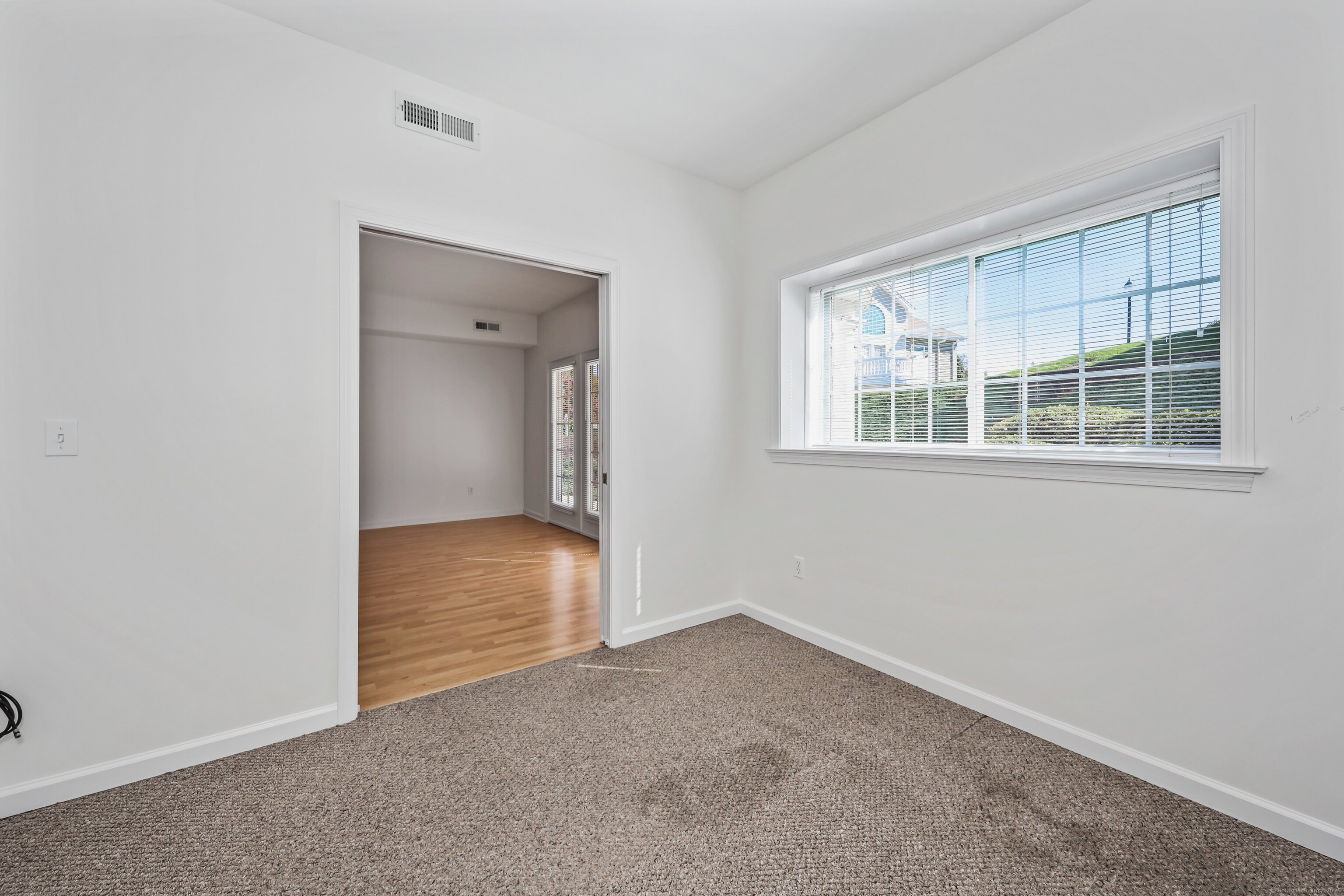 211 Pine Hill Boulevard, Unit 211 Plymouth, CT 06782 - Photo 18 of 35 a view of an empty room with wooden floor and a window