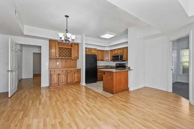 a kitchen with stainless steel appliances kitchen island granite countertop a refrigerator and a stove top oven