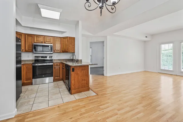 a kitchen with stainless steel appliances granite countertop a stove a sink and a microwave