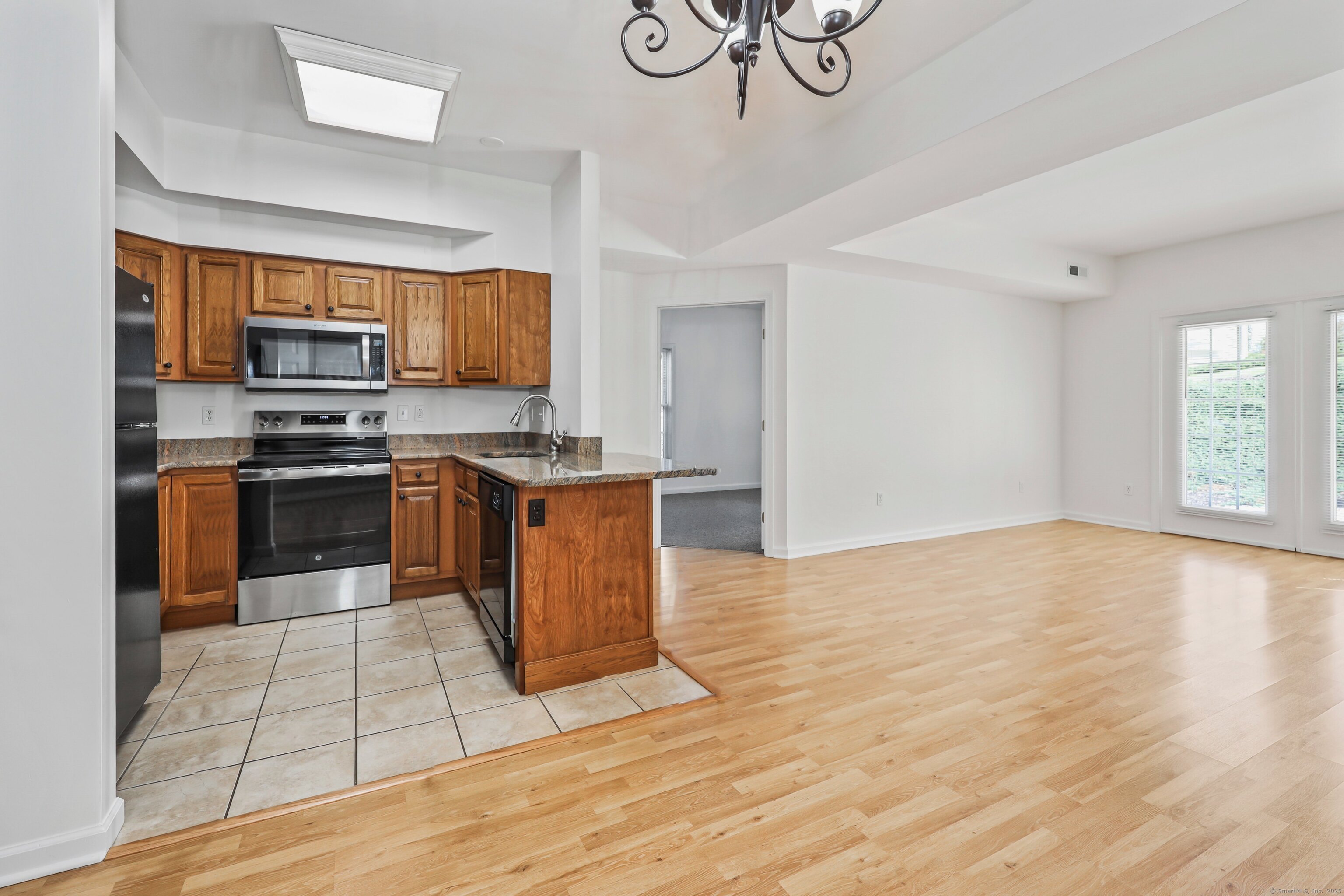 211 Pine Hill Boulevard, Unit 211 Plymouth, CT 06782 - Photo 8 of 35 a kitchen with stainless steel appliances granite countertop a stove top oven a sink and a microwave