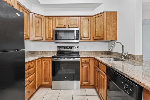 a kitchen with stainless steel appliances granite countertop a refrigerator sink and microwave