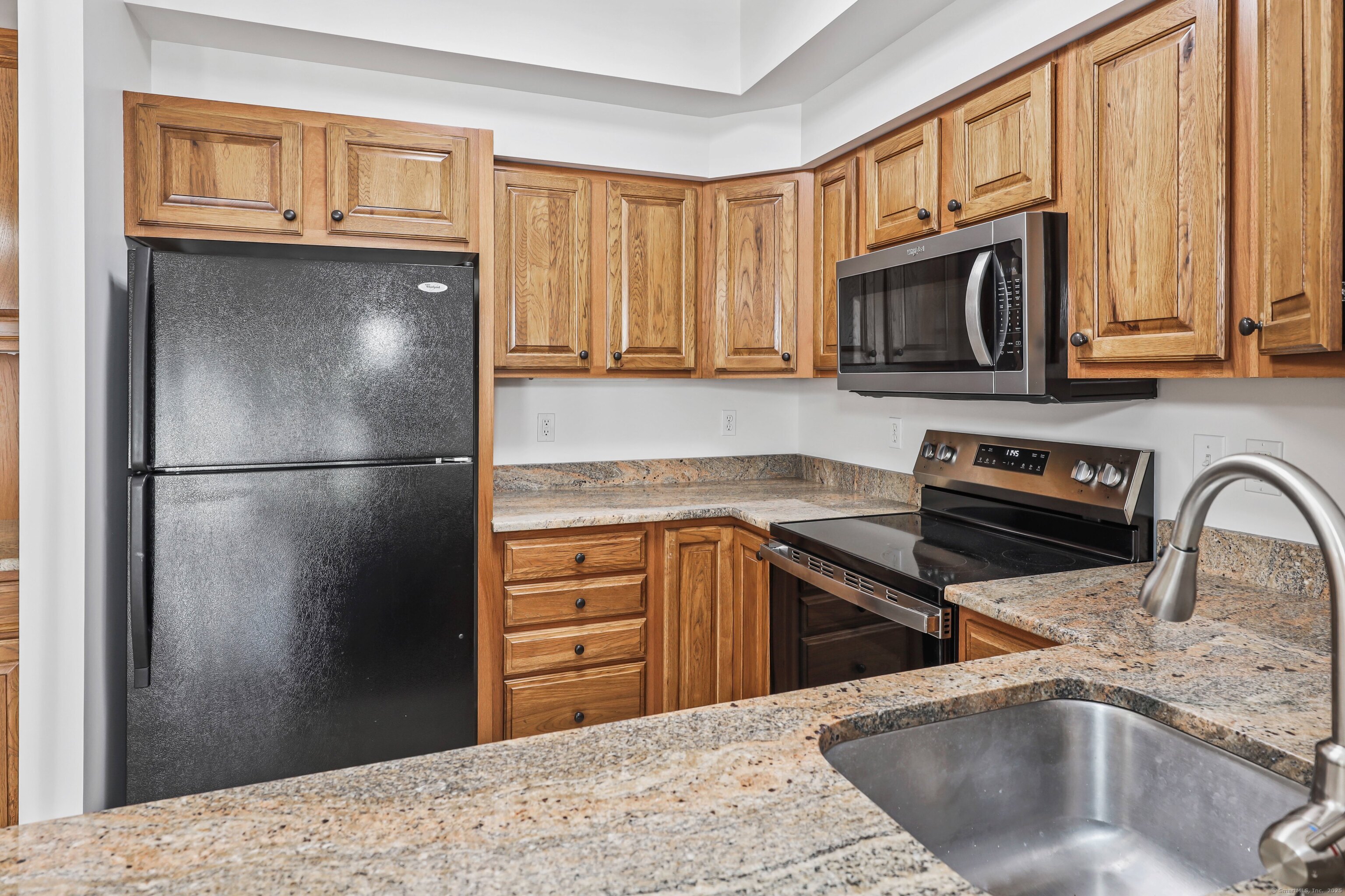 211 Pine Hill Boulevard, Unit 211 Plymouth, CT 06782 - Photo 10 of 35 a kitchen with stainless steel appliances granite countertop a refrigerator sink and microwave