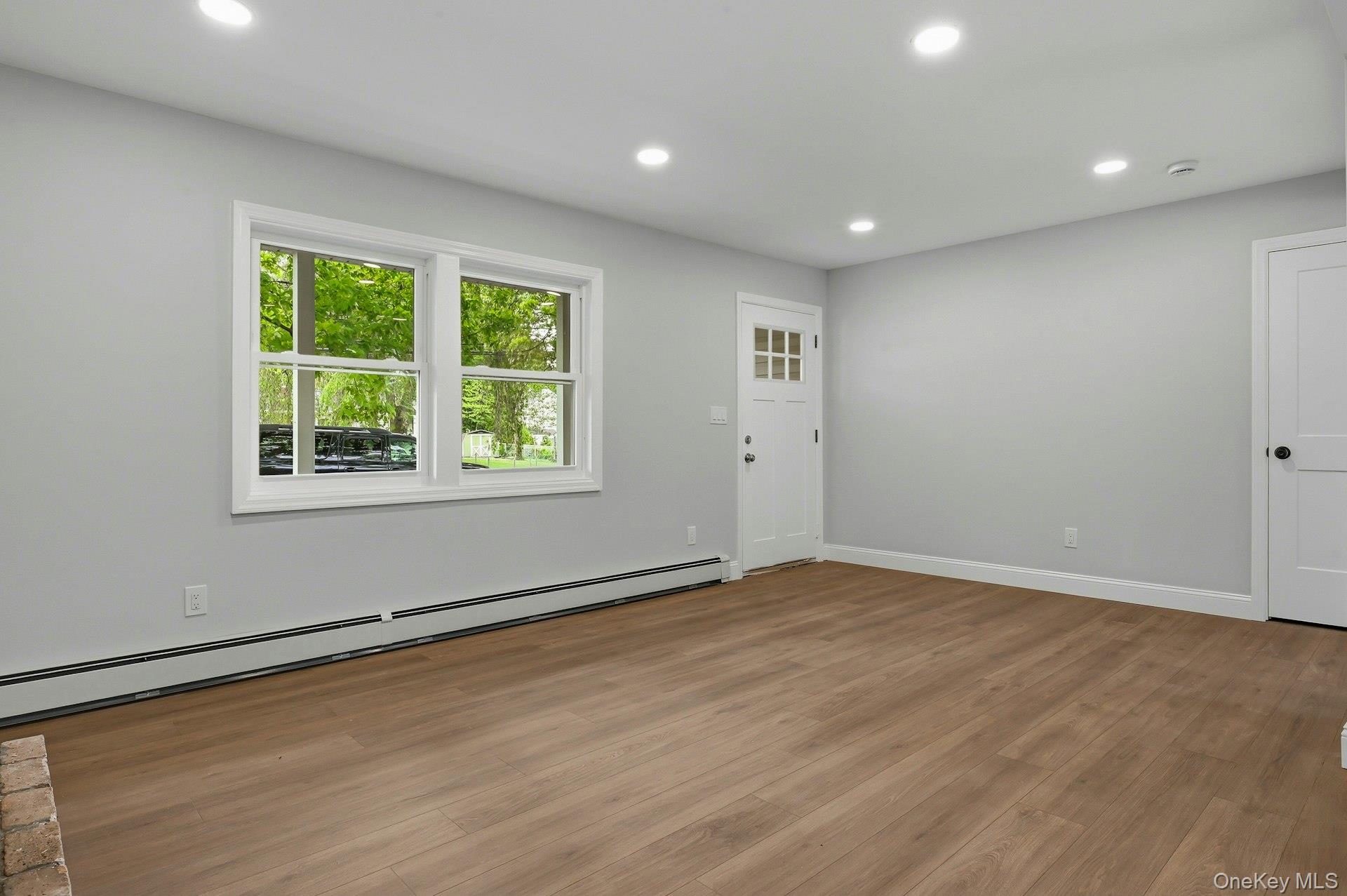 101 Rustic Road Centereach, NY 11720 - Photo 15 of 42 a view of an empty room with wooden floor and a window