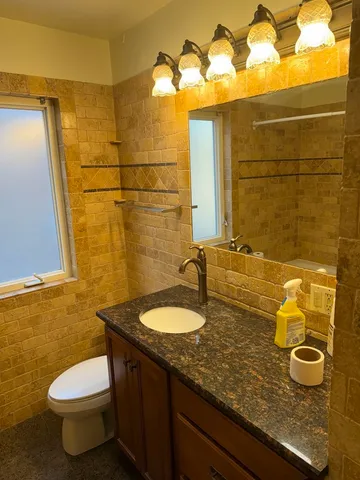 a bathroom with a granite countertop sink and a mirror
