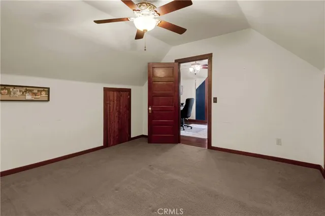 an empty room with wooden floor closet and windows