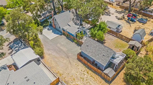 an aerial view of a house with a yard and a large tree