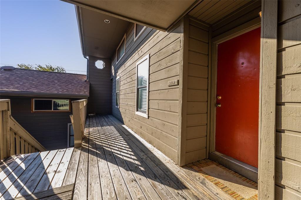 Doorway to property with a deck and a shingled roof