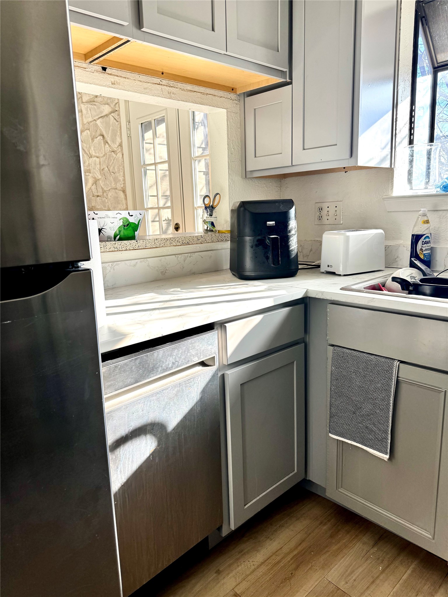 3506 Speedway, Unit 302 Austin, TX 78705 - Photo 8 of 27 Kitchen featuring gray cabinetry, light countertops, freestanding refrigerator, and light wood-type flooring
