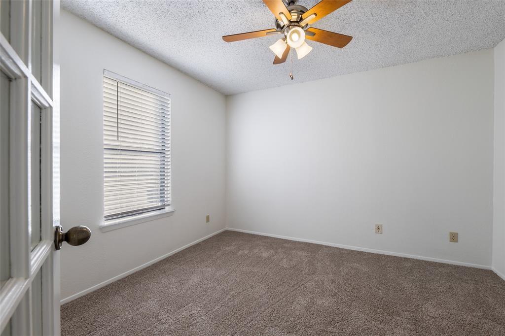 3506 Speedway, Unit 302 Austin, TX 78705 - Photo 10 of 27 Carpeted spare room featuring a textured ceiling and a ceiling fan
