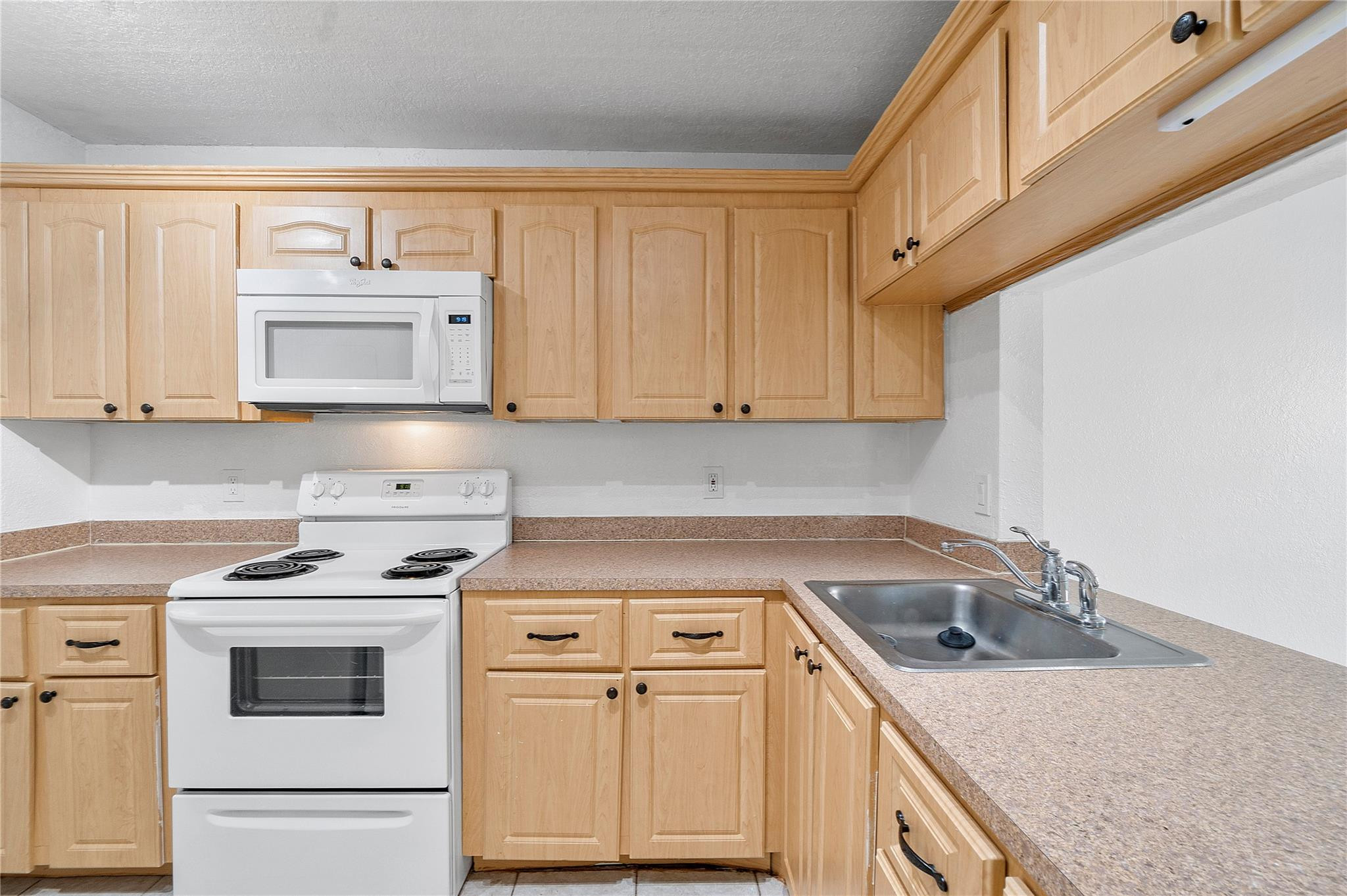 10054 Winding Lake Road, Unit 104 Sunrise, FL 33351 - Photo 3 of 13 a kitchen with a sink stove and cabinets