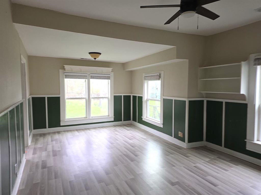 612 North Adelaide Street Terrell, TX 75160 - Photo 4 of 11 Dining room with light wood finished floors, a ceiling fan, and wainscoting