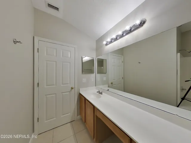 a bathroom with a tub sink and mirror