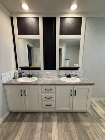 a bathroom with a double vanity sink and mirror