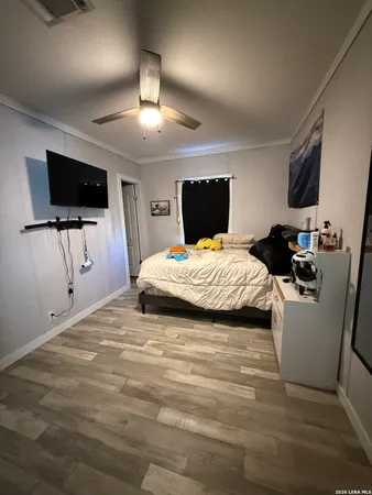 a bedroom with a bed a flat screen tv and a couch