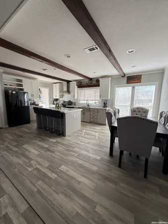 a living room with a couch and a dining table with wooden floor