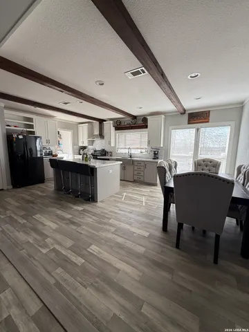 a living room with a couch and a dining table with wooden floor