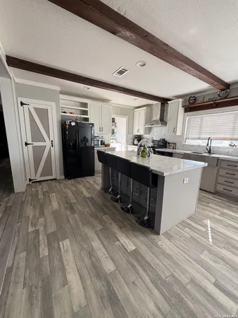 a large kitchen with stainless steel appliances granite countertop a stove and cabinets