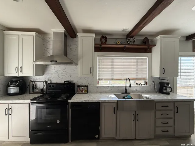a kitchen with granite countertop a sink a stove and cabinets