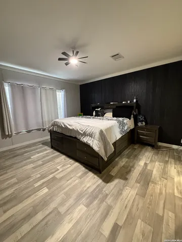 a spacious bedroom with a bed and a chandelier