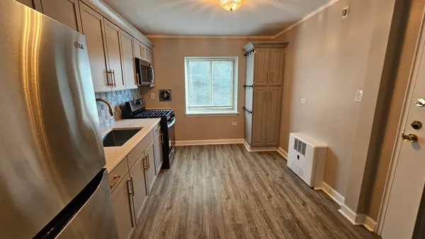 a kitchen with wooden floors and glass door