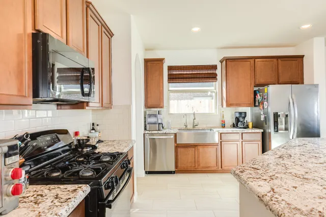 a kitchen with stainless steel appliances a stove a sink a refrigerator and cabinets
