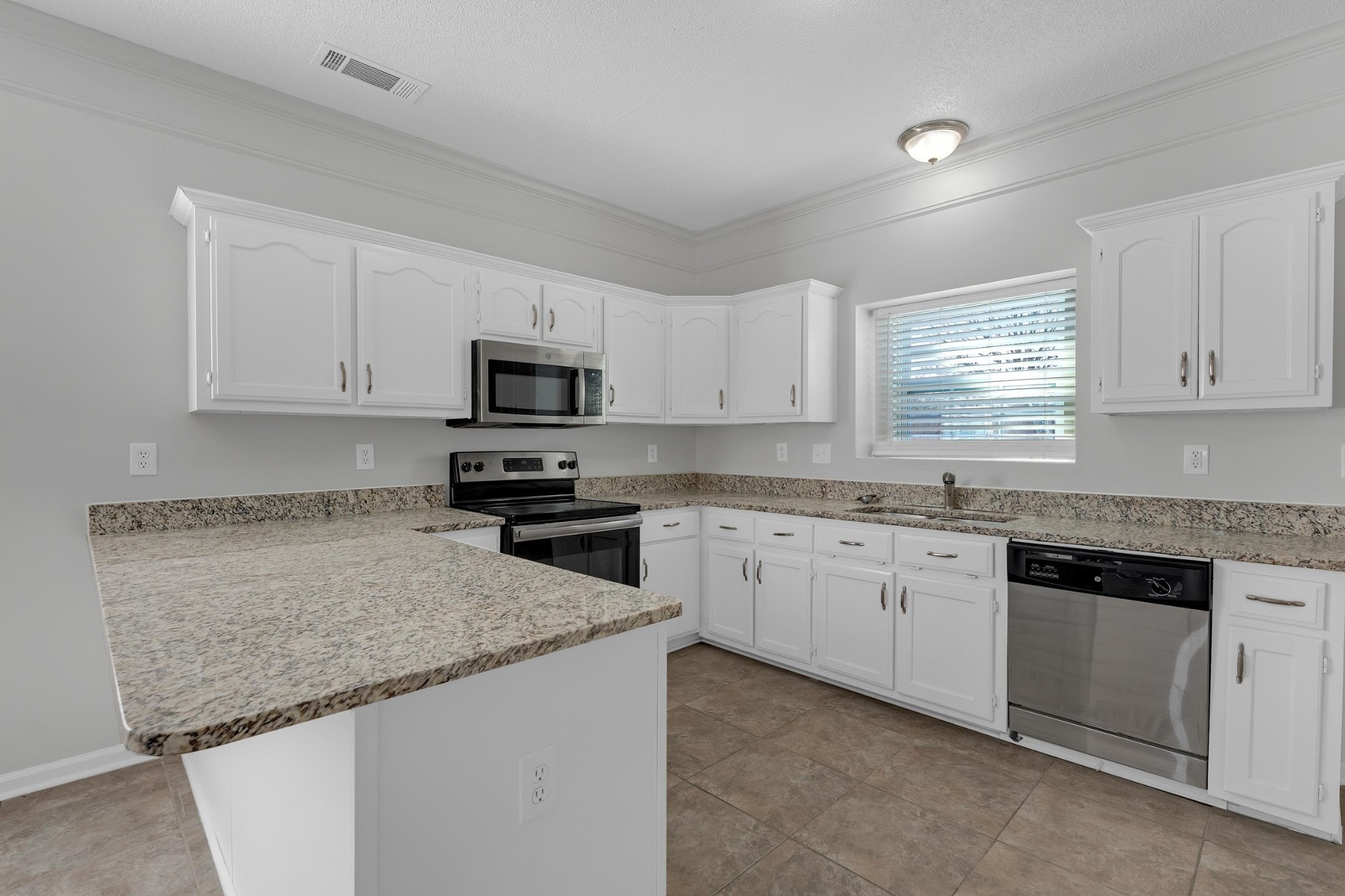 2593 Kate Bond Road Memphis, TN 38133 - Photo 3 of 33 a kitchen with granite countertop white cabinets sink and stainless steel appliances