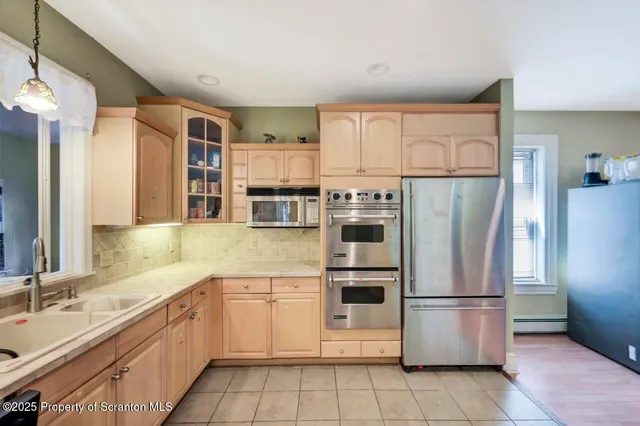 a kitchen with stainless steel appliances a refrigerator sink and cabinets