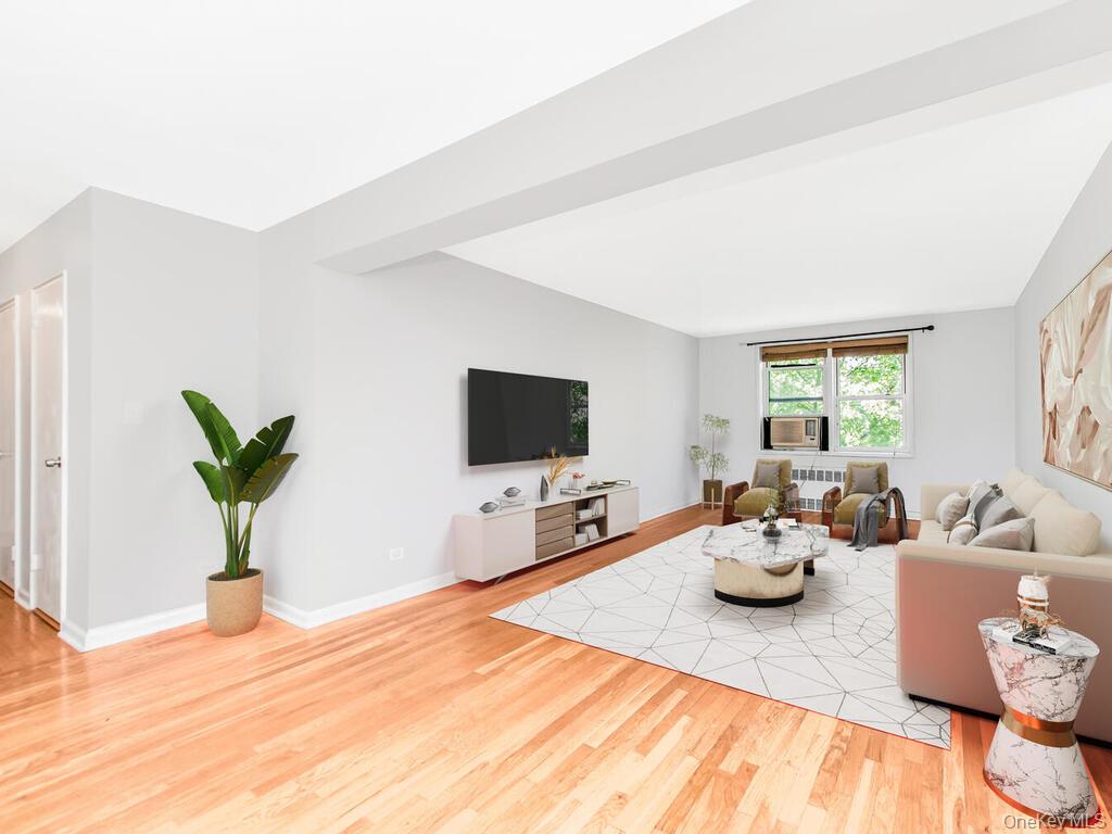 Living area with light wood-style flooring and radiator