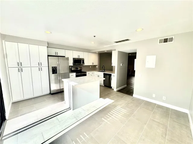 a kitchen with stainless steel appliances a refrigerator and a stove top oven