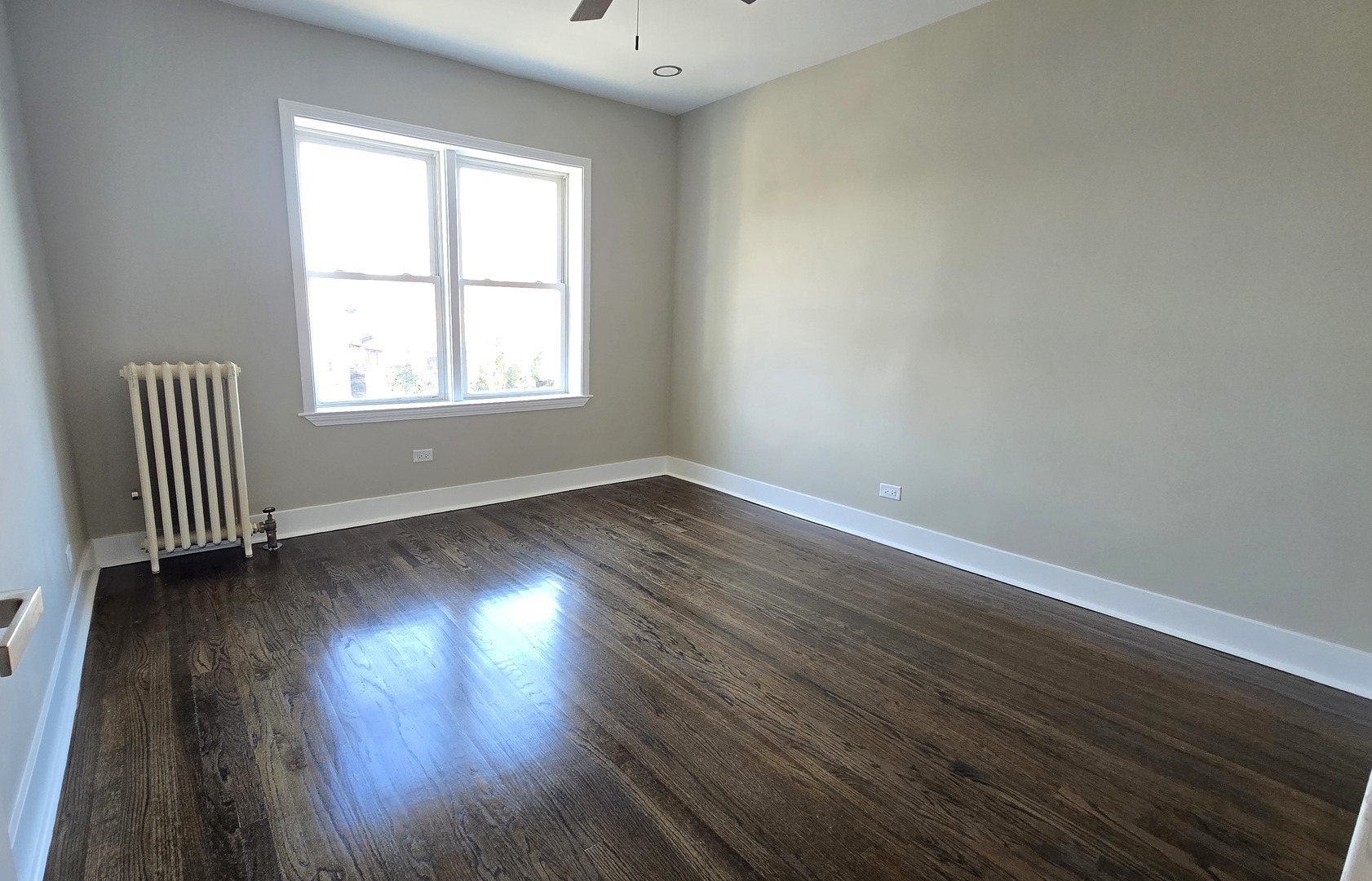 3051 North Austin Avenue, Unit 2F Chicago, IL 60634 - Photo 7 of 9 an empty room with wooden floor and windows