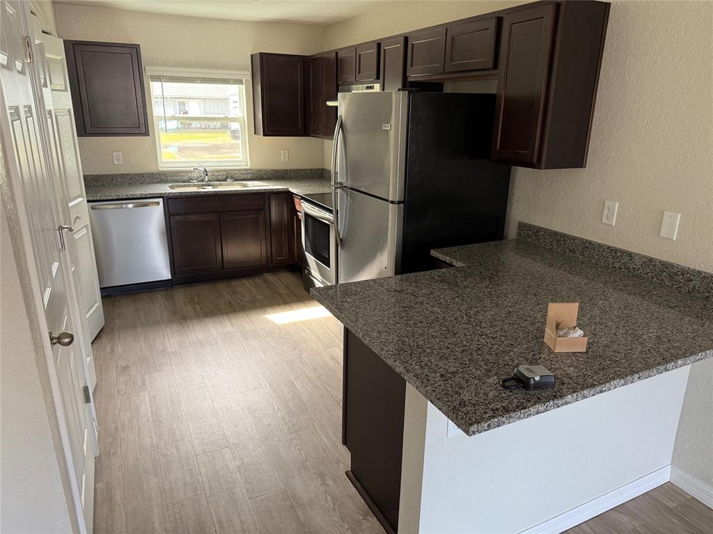 316 Pleasant Grove Road, Unit 2 Inverness, FL 34452 - Photo 12 of 12 a kitchen with granite countertop a refrigerator and a sink