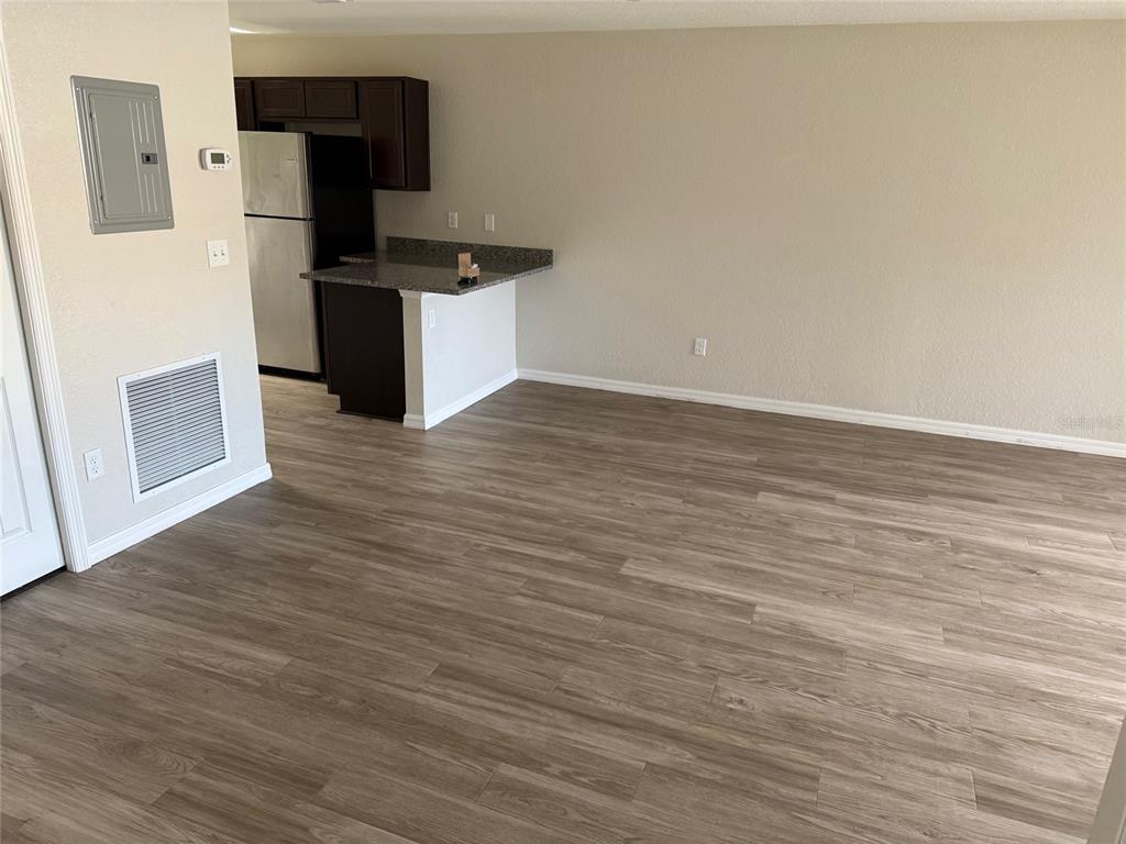 316 Pleasant Grove Road, Unit 2 Inverness, FL 34452 - Photo 10 of 12 a kitchen with stainless steel appliances wooden floor and a refrigerator