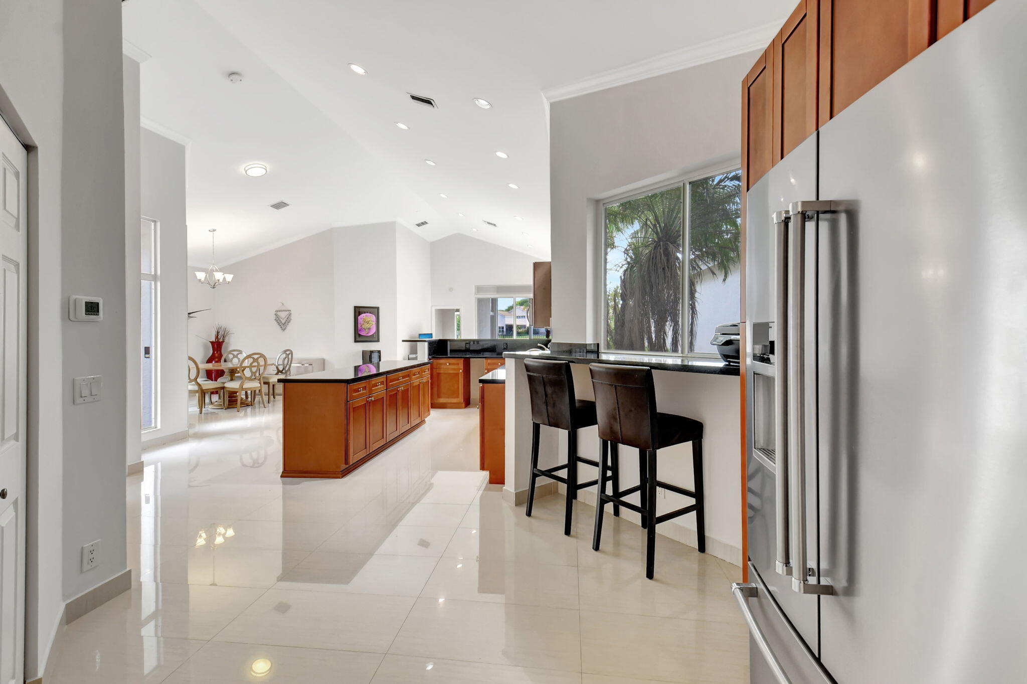 2469 Northwest 66th Drive Boca Raton, FL 33496 - Photo 17 of 45 a dining hall with stainless steel appliances kitchen island granite countertop furniture and a view of living room