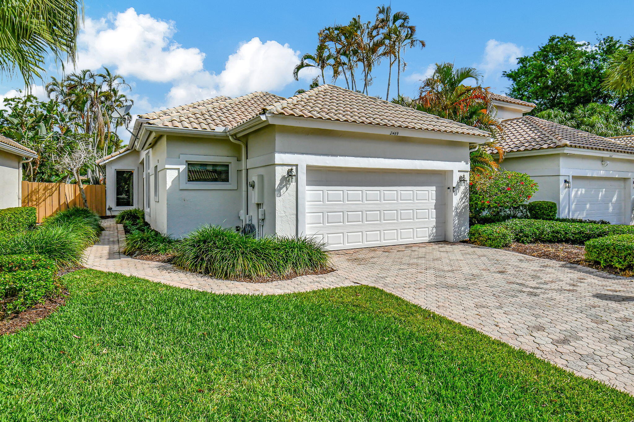 2469 Northwest 66th Drive Boca Raton, FL 33496 - Photo 2 of 45 a front view of a house with a garden and plants