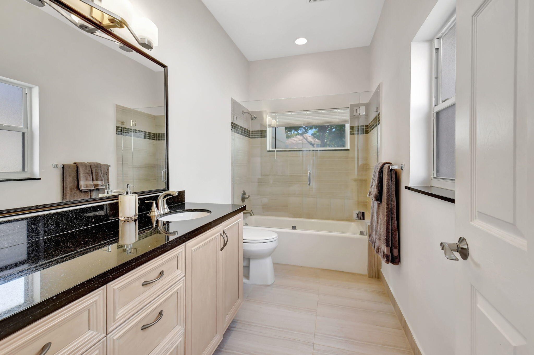 2469 Northwest 66th Drive Boca Raton, FL 33496 - Photo 25 of 45 a spacious bathroom with a double vanity sink a toilet a bathtub and shower